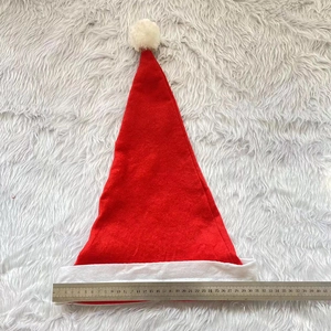 Vue à plat d'un bonnet de Noël rouge avec bordure blanche mesurant 30 cm de largeur