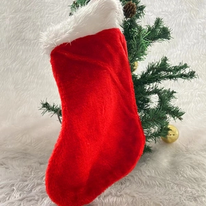 Classic red plush Christmas stocking with white faux fur trim for holiday home decoration