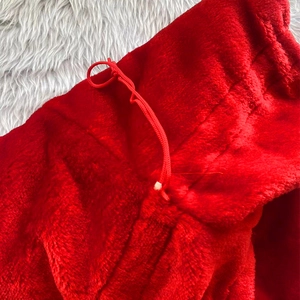 Detail of red velvet Christmas gift bag fabric texture and matching drawstring cord