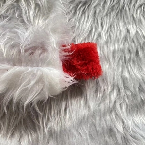 Macro detail of soft red and white plush fabric texture for Christmas decorations