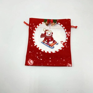 Close-up of a red Christmas drawstring gift bag featuring a cute snowman design and gold bell