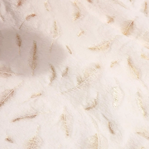 White faux fur Christmas tree skirt featuring elegant gold leaf and feather print