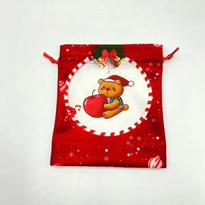 Detail of red Christmas drawstring bag with cute bear, pine needles and golden bells