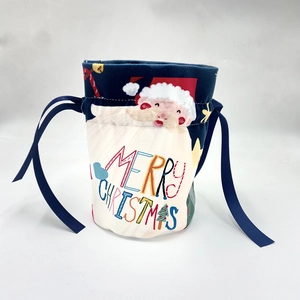 Detail of Christmas drawstring gift bag with Santa Claus print and blue ribbon