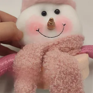 Detailed close-up of a pink plush snowman with soft wool fabric and knit scarf