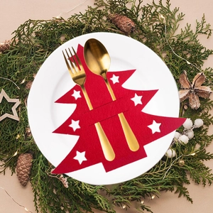 Christmas tree shaped red felt cutlery holder with white stars on festive plate