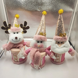 Close-up of pink Christmas plush gift jars featuring Santa, Snowman and Reindeer characters