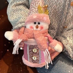 Close-up of a pink snowman candy jar featuring sequin details and plush fabric accents