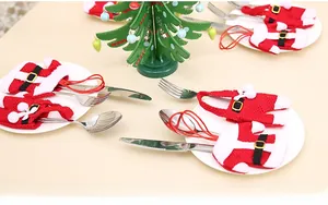 Detail view of Christmas cutlery holders in Santa suit design with red fabric and fur trim