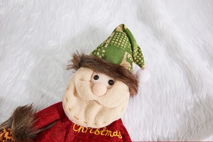Detailed view of handmade burlap Santa decoration with green plaid hat and Christmas embroidery