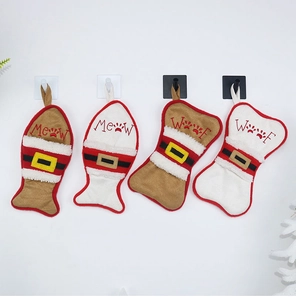 Detail of four Christmas stockings for pets in bone and fish shapes hanging on a wall