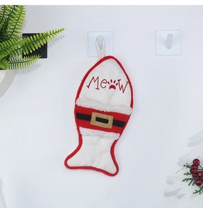 Detail of fish-shaped Christmas stocking with Meow embroidery and red berry decor