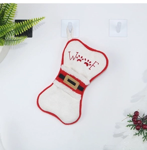 Detail of bone-shaped pet Christmas stocking with embroidered paws and Santa belt design