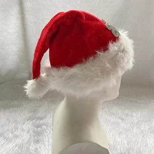 Detail der roten Samt-Weihnachtsmütze mit weißem Plüschbesatz und silbernem Festdekor