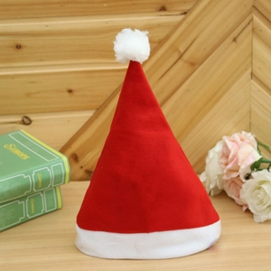 Classic red plush Christmas hat with white fur trim on a cozy wooden tabletop