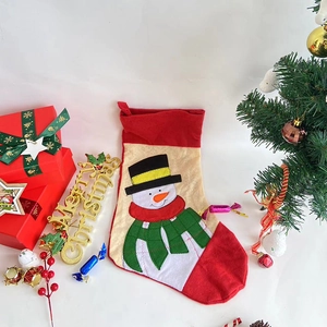 Detail of red and cream Christmas stocking featuring a festive snowman applique design