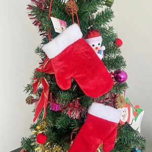 Gants de Noël en velours rouge avec bordure en fourrure blanche sur un sapin festif