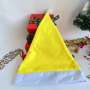 Classic yellow felt Santa hat with white trim in festive Christmas holiday setting