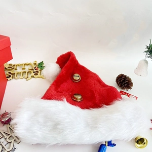 Bonnet de Noël en peluche avec cloches dorées et décorations festives sur fond blanc
