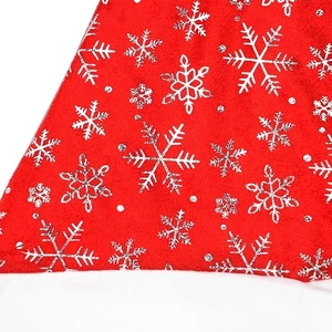 Détail de tissu de Noël en velours rouge avec flocons blancs et paillettes argentées