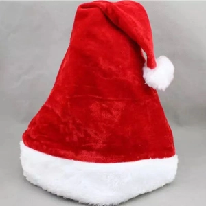 Flat lay of a classic red plush Christmas hat with a white faux fur brim and pompom detail