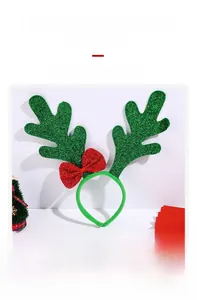 Detailed view of Christmas reindeer antler headband with green glitter and red bow