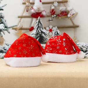 Détail de bonnets de Noël en velours rouge avec motifs de flocons dorés et argentés