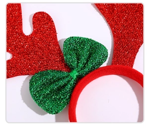 Close-up of glittery red reindeer antlers with a green sequin bow on a plush headband