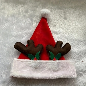 Classic red plush Christmas hat with brown reindeer antlers and holly leaf accents