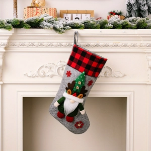 Detail of grey felt Christmas stocking with 3D gnome and red plaid cuff on fireplace
