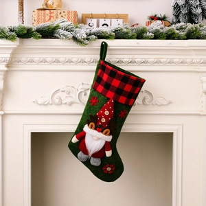 Detail of green Christmas stocking featuring a 3D plush gnome and red buffalo plaid cuff