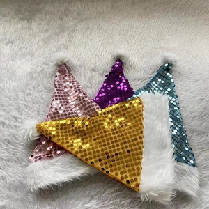 Détail de bonnets de Noël à paillettes scintillantes rose, violet, bleu et or avec peluche