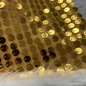 Gros plan détaillé des paillettes dorées sur le bonnet de Noël avec motif écailles de poisson