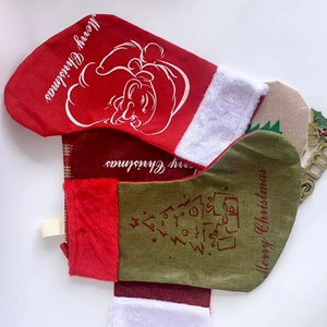 Flat lay detail of linen Christmas stockings with Santa embroidery and faux fur trim
