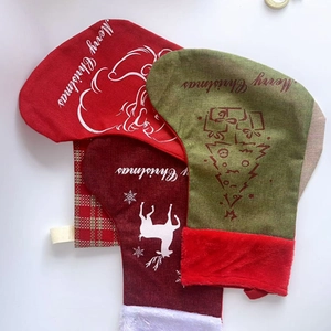 Close-up of three burlap Christmas stockings with elk embroidery and soft plush cuffs