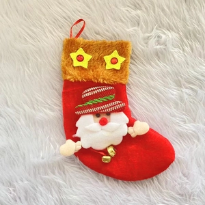 Chaussette de Noël rouge avec figurine de Père Noël et clochettes sur fond de fourrure