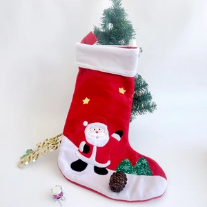 Detailed view of 3D Santa Claus and star embroidery on classic red Christmas stocking