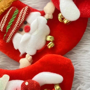 Gros plan d'une chaussette de Noël en velours rouge avec Père Noël 3D et clochettes