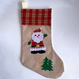 Christmas stocking with Santa Claus and green tree embroidery on rustic burlap fabric