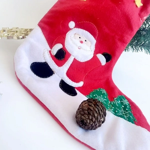 Christmas stocking with Santa Claus and green tree patches on festive white background