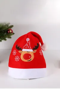 Dettaglio del cappello di Natale in peluche rosso con renna ricamata e fiocchi di neve