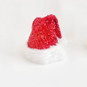 Detail shot of sparkling red sequins and soft white plush trim on a festive Christmas hat