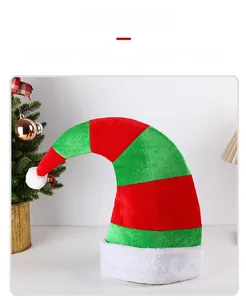 Vue détaillée du bonnet de lutin de Noël rayé avec texture en velours et pompons en peluche