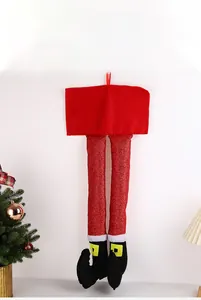 Makroaufnahme glitzernder roter Elfenbeine als Weihnachtsdeko mit schwarzen Stiefeln
