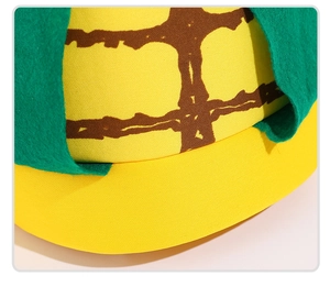 Détail du chapeau de fête en forme de maïs avec texture quadrillée jaune et feuilles en feutre