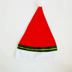 Cappello di Natale rosso classico con pompon bianco e nastro verde festivo su sfondo bianco