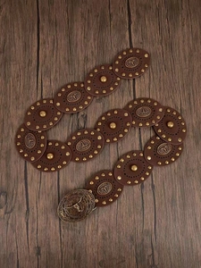 Detailed macro of western vintage belt featuring bull head buckle and metallic rivets