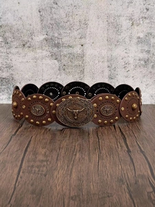 Macro detail of Western vintage leather belt with metal rivets and longhorn bull buckle