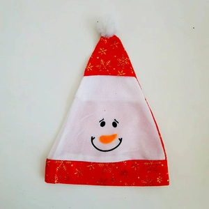 Dettaglio cappello di Natale con motivo a fiocchi dorati e viso di pupazzo di neve carino