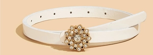 Détail de ceinture blanche avec boucle fleur dorée ornée de strass brillants et élégants